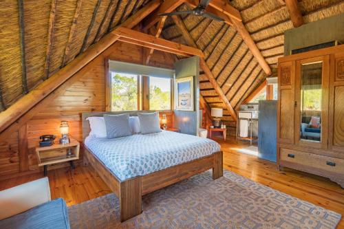 a bedroom with a bed in a wooden cabin at Mountain Cabin private hot tub and swimming pool in Wolseley