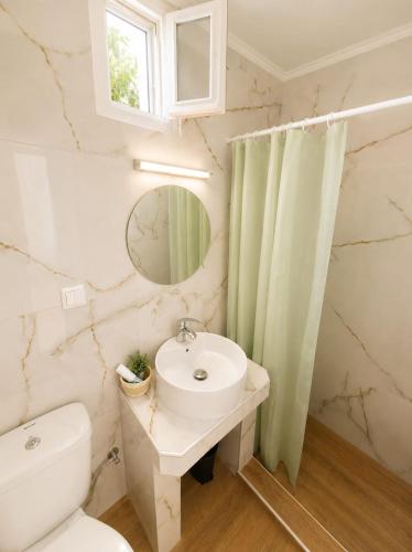 a bathroom with a sink and a toilet and a mirror at Amaya Pine Studio in Panagia