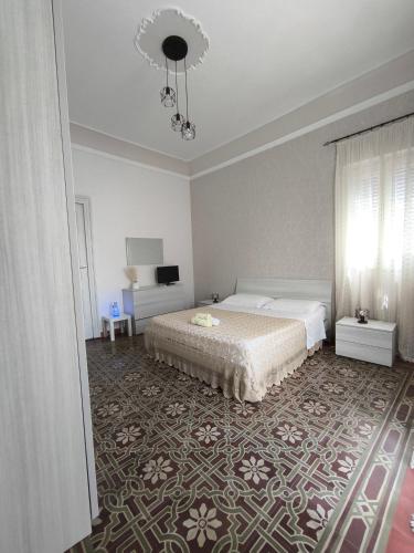 a bedroom with a bed and a chandelier at la casa del viaggiatore in Bronte