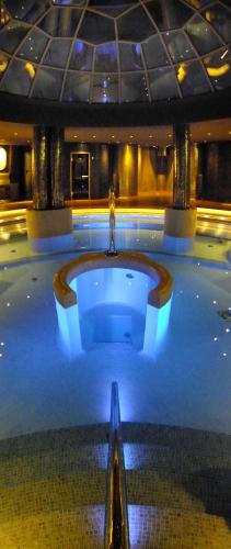 a large tub in a building with blue lights at Cumbria Spa Hotel 3* Sup in Ciudad Real