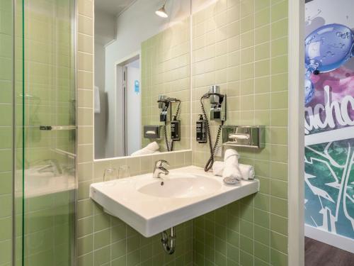 a bathroom with a sink and a mirror at ibis Styles Hamburg Alster City in Hamburg