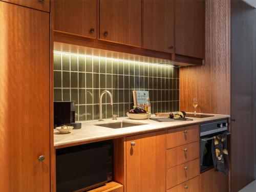 a kitchen with a sink and a counter top at Adina Hobart in Hobart