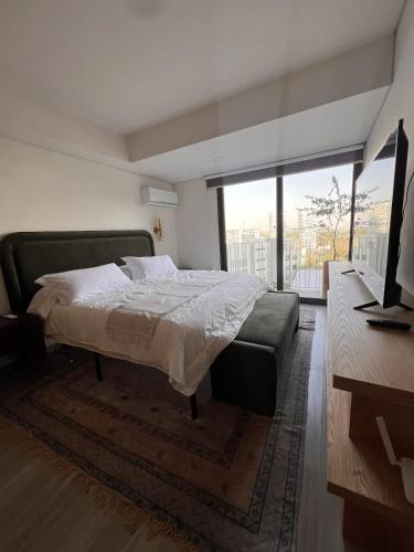 a bedroom with a bed and a large window at Visa Trip Cozy Stay in Guadalajara