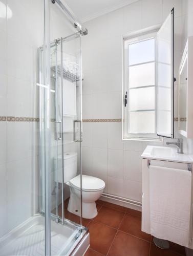 a bathroom with a toilet and a glass shower at Casa Raxón Ferrol in Ferrol