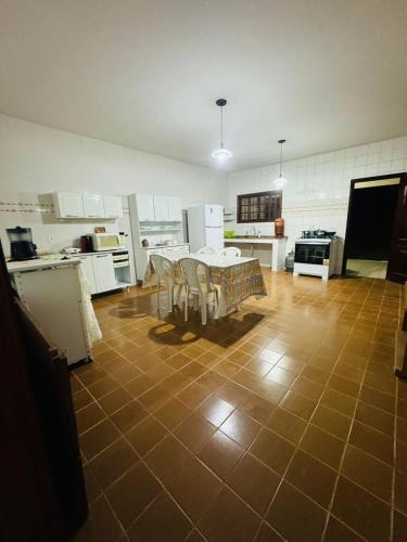 a large kitchen with a table and chairs in it at Casa do Carol Sana in Macaé