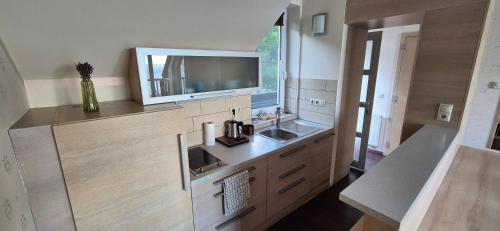 a kitchen with a sink and a tv on the wall at T8 Sunset Tihany 19 in Tihany