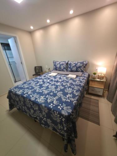 a bedroom with a bed with a blue bedspread at Refúgio à Beira-Rio em Condomínio Exclusivo in Barreirinhas