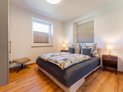 a bedroom with a large bed and two windows at Bruggerheim in Niedernsill