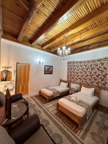 a bedroom with two beds and a living room at OROM PONORAMA VIEW old city in Bukhara