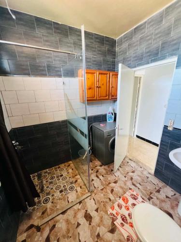 a bathroom with a shower and a toilet and a sink at maison hajji in Mezraya