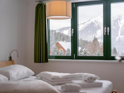 a bedroom with a bed with a view of a snowy mountain at Passhöhe in Hohentauern