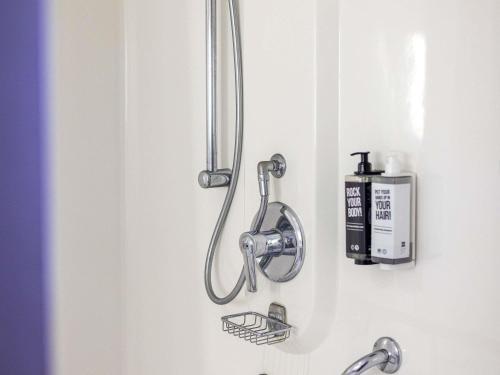 a shower head on the wall of a bathroom at ibis London City - Shoreditch in London