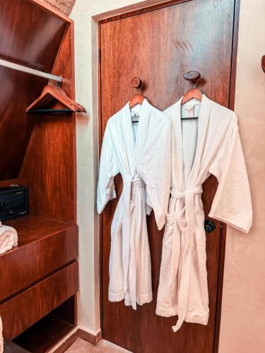 a group of white robes hanging on a door at Danselis Boutique Hotels in Telchac Puerto
