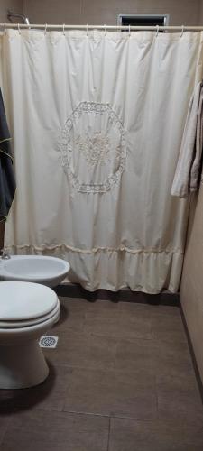 a bathroom with a toilet and a shower curtain at La Elvira in San Pedro