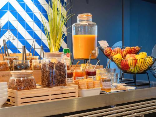 a buffet with different types of food and orange juice at ibis Manosque Cadarache in Manosque