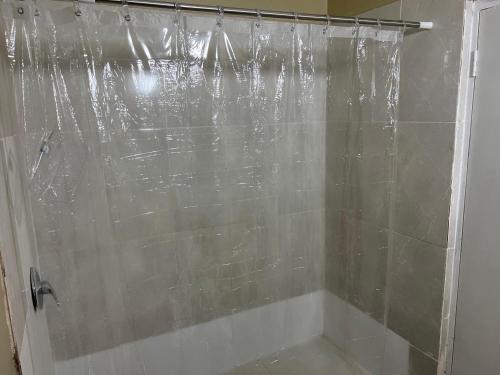a shower in a bathroom with a shower curtain at Manor Villas in Kingston