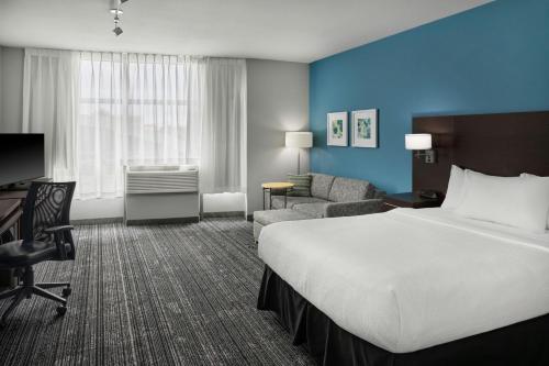 a hotel room with a bed and a chair and a desk at TownePlace Suites by Marriott Springfield in Springfield