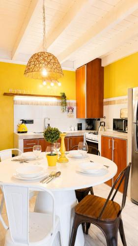 a kitchen with a white dining table and chairs at Cabañas Sublime Bolson in El Bolsón