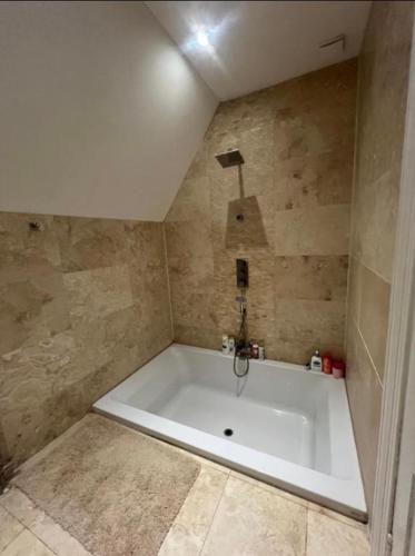 a large white bath tub in a bathroom at Dundee Beds in Dundee