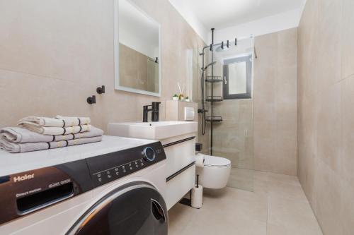 a bathroom with a washing machine and a sink at Apartments by the sea Balica Rat, Omis - 1065 in Omiš
