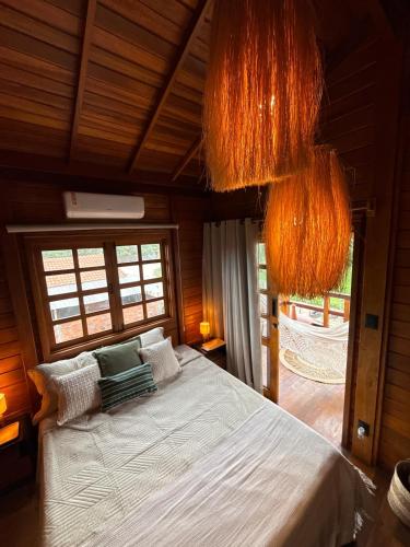 a bedroom with a bed in a room with windows at VENTO A GOSTO Chalet - Atins in Atins