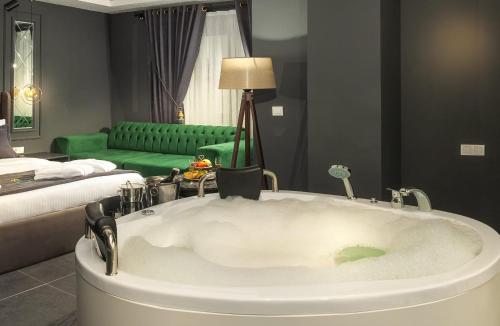 a bath tub in a room with a bed and a couch at Kral As Suite Hotel in Istanbul