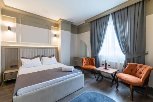 a hotel room with a bed and two chairs at Kral As Suite Hotel in Istanbul