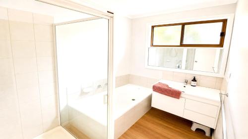 a bathroom with a tub and a sink and a shower at Blue Bay Escape in Venus Bay