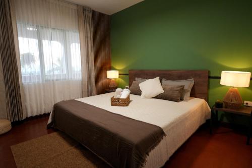 a bedroom with a large bed with a green wall at Alma Terra Campestre in Ginebra