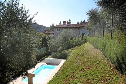 a swimming pool in a garden with a house at Dos del Sul in Roe