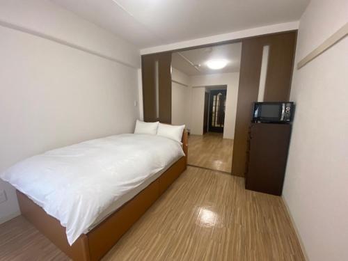 a bedroom with a bed and a television in it at メープル桑園駅311 in Sapporo