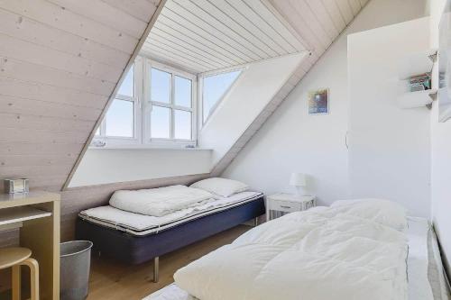 a attic bedroom with a bed and a window at 40128-Juelsminde-Strandengen-41 in Juelsminde