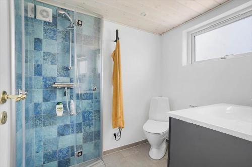 a bathroom with a shower and a toilet and a sink at 40152-Juelsminde-Mirabellevej-5 in Juelsminde