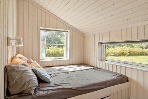 a bed in a small room with a window at 30439-Odder-Strandvaenget-74 in Odder
