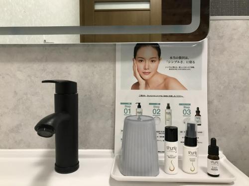 a sign in a bathroom with products on a sink at 北軽井沢 SPAHA Karuizawa Forest Resort Villa YB1 in Kita-karuizawa