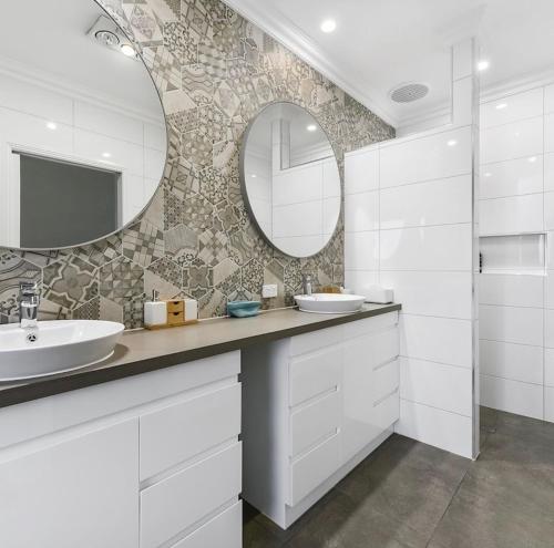 a bathroom with two sinks and a mirror at Luxurious Home on the Beachside in Port MacDonnell