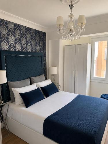 a bedroom with a blue and white bed with a chandelier at Burgos Spa and Cathedral in Burgos