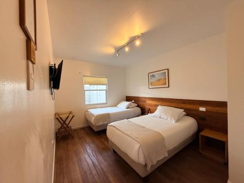 a hotel room with two beds and a window at Pampa Hotel Boutique in Iquique
