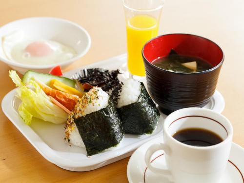 a plate of sushi and a cup of coffee on a table at Koga Central Hotel in Koga