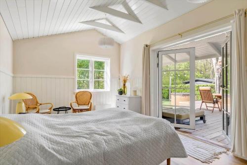 a bedroom with a large bed and a patio at 30338-Odder-Skovlunden-11 in Odder
