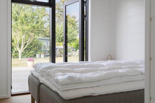 a large bed in a room with a large window at 30315-Odder-Grindevej-22 in Odder