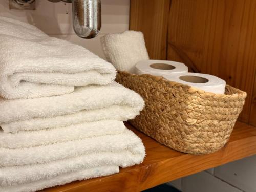 a pile of towels and rolls of toilet paper on a shelf at Pampa Hotel Boutique in Iquique