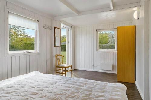 a white bedroom with a bed and two windows at 30463-Odder-Solbakken-14 in Odder