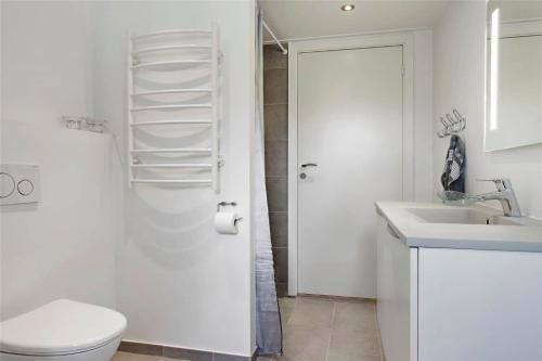 a white bathroom with a toilet and a sink at 30463-Odder-Solbakken-14 in Odder