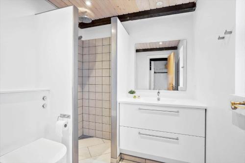 a white bathroom with a sink and a mirror at 40154-Juelsminde-Nattergalevej-10 in Juelsminde