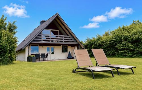 two chairs sitting in the grass in front of a house at Awesome Home In Haderslev With Wifi in Haderslev