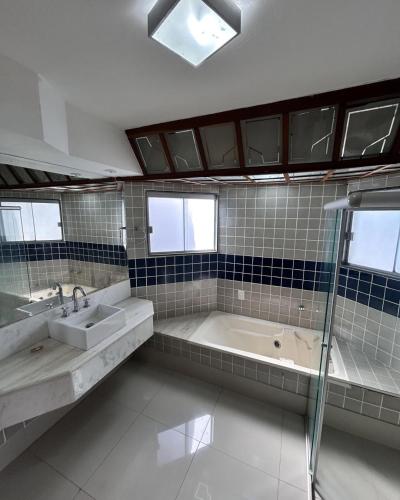 a bathroom with a tub and a sink and a shower at Pousada Recanto do Bosque in Luziânia