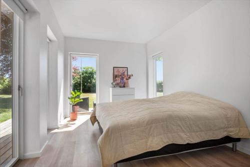 a bedroom with a bed and a large window at 30490-Saksild-Praesteager-221 in Saksild