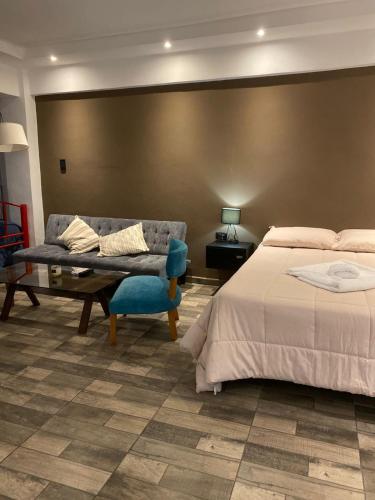 a hotel room with a bed and a couch at Complejo Terranova in Aimogasta