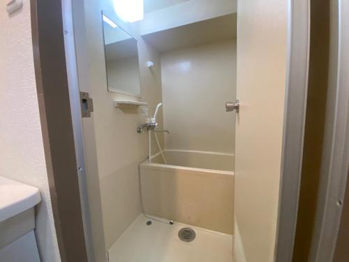 a bathroom with a tub and a shower with a mirror at メープル桑園駅311 in Sapporo